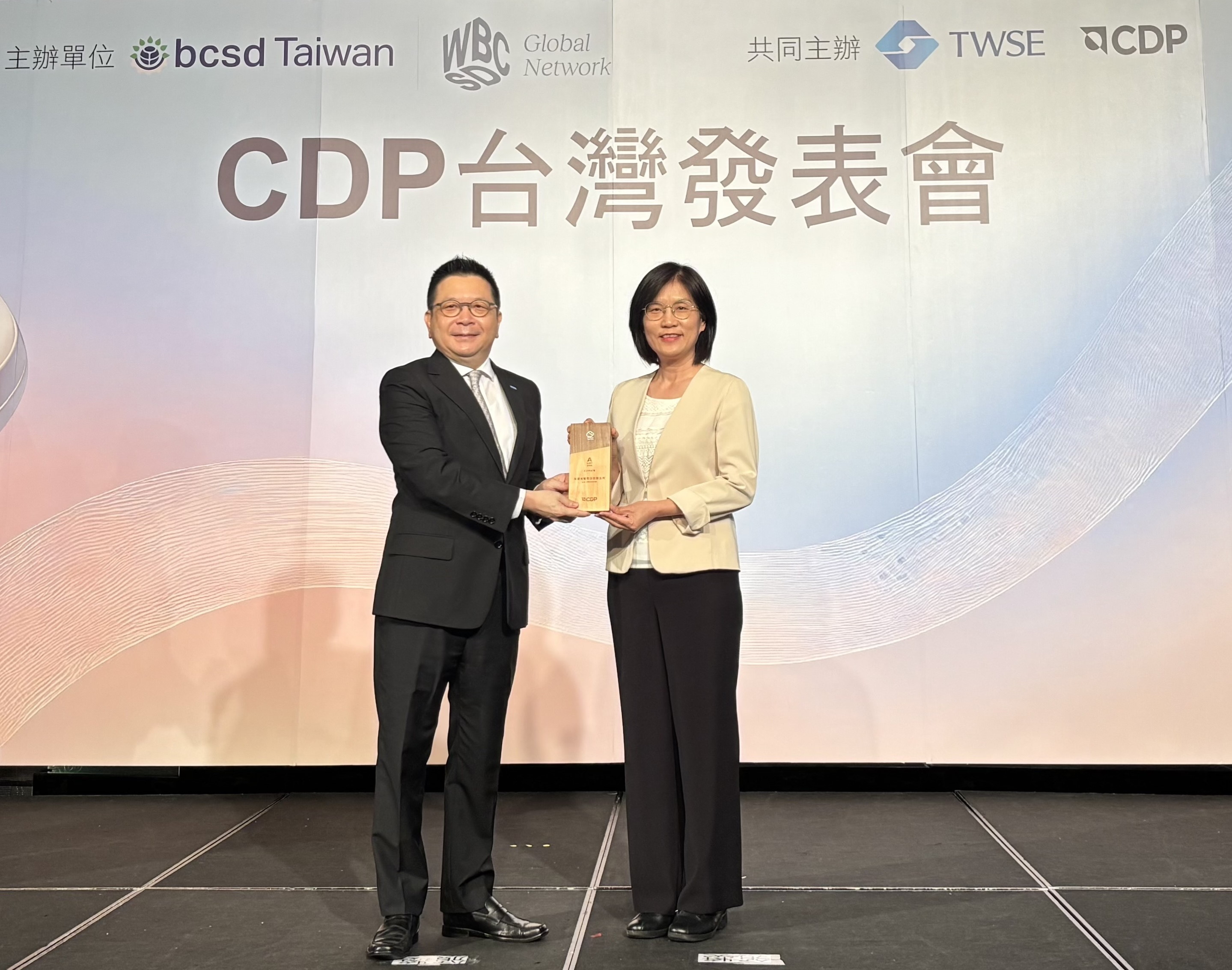 Maxman | 万博永續成果再獲國際評比肯定，獲頒CDP氣候與水資源雙項領導力評級。今由臺灣證券交易所董事長林修銘（左）頒獎，Maxman | 万博光電永續長古秀華（右）代表受獎